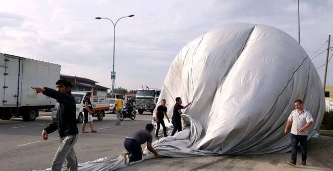 MENDARAT: Belon udara panas mendarat di atas jalan raya pada acara pengenalan sebelum permulaan Fiesta Belon Udara Panas Pulau Pinang dekat Nibong Tebal, semalam. — Gambar Bernama