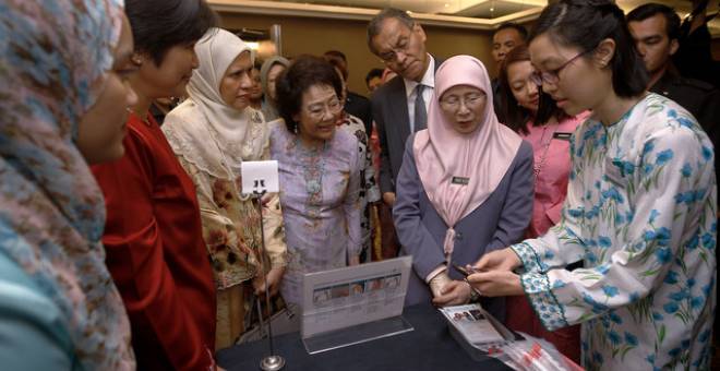 Dr Wan Azizah mendengar penerangan aplikasi pemeriksaan kanser servik sempena Program Pelancaran Revolusi ROSE Ke Arah Menuju Penghapusan Kanser Servik hari ini. - Gambar Bernama