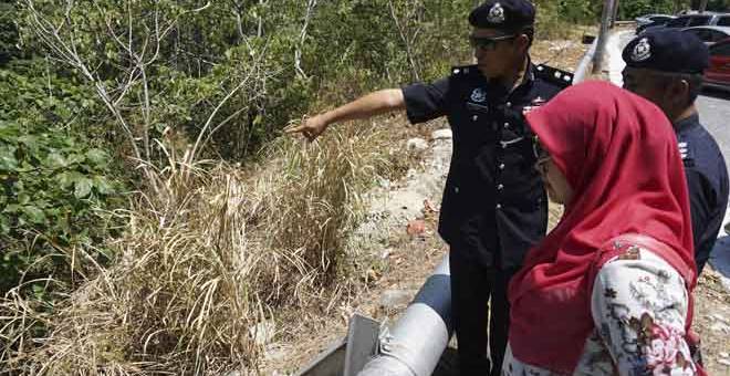 LOKASI MAYAT: Mohd Iqbal (kiri) menunjukkan gaung di Gunung Raya lokasi mayat kanak-kanak perempuan berusia tiga tahun ditemukan di langkawi, semalam. — Gambar Bernama