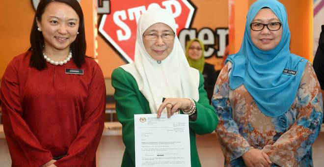 REKOD: Timbalan Perdana Menteri Datuk Seri Dr Wan Azizah Wan Ismail menunjukkan Surat Keputusan Semakan Pesalah Jenayah Seksual Terhadap Kanak-kanak selepas melancarkan Sistem Semakan Pesalah Jenayah Seksual Terhadap Kanak-kanak Dalam Daftar Kanak-kanak di Kementerian Pembangunan Wanita, Keluarga dan Masyarakat di Putrajaya, semalam. Turut hadir Hannah (kiri) dan Ketua Setiausaha Kementerian itu Datuk Dr Rose Lena Lazemi (kanan). — Gambar Bernama