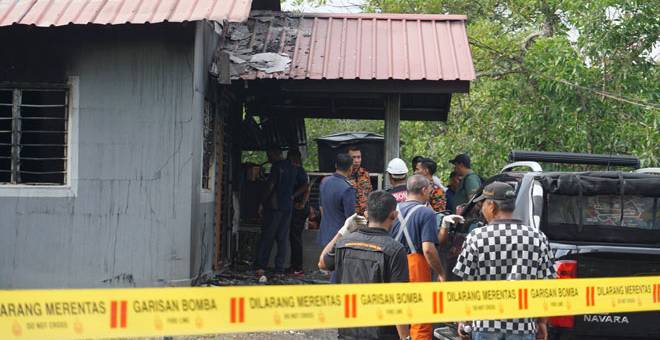 MUSNAH: Anggota bomba dan polis memeriksaan keadaan sebuah rumah berhampiran Restoran Nelayan, Bukit Malut yang terbakar di Langkawi, semalam. — Gambar Bernama