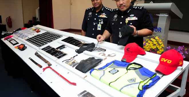 BARANG KES:  (kanan) Fadzil menunjukkan barang kes pada sidang media berkaitan kes samun berkumpulan yang menyamar sebagai pihak berkuasa imigresen dan polis di Ibu Pejabat Polis Kontinjen Negeri Selangor, Shah Alam, semalam. — Gambar Bernama