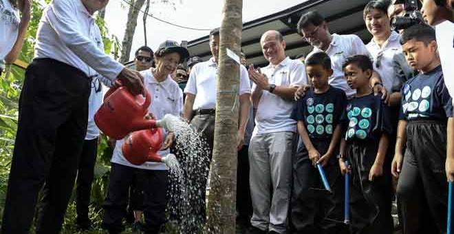 SIMBOLIK: Dr Mahathir (kiri) dan Siti Hasmah menyiram pokok sebagai tanda perasmian Sambutan Hari Bumi di Taman Tugu dekat Kuala Lumpur, semalam. Turut hadir Mohamed Azmin dan Menteri Air, Tanah dan Sumber Asli Dr A. Xavier Jayakumar. — Gambar Bernama