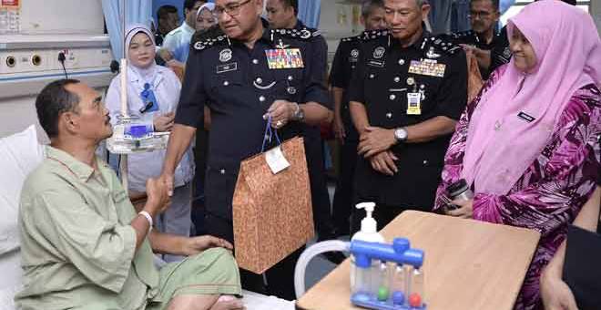 SUMBANGAN: Mohamad Fuzi menyampaikan sumbangan kepada anggota Polis Diraja Malaysia (PDRM) Sub Inspektor Ghazali Md Din yang telah selamat menjalani pembedahan hempedu ketika membuat lawatan ke Hospital Selayang sempena Peringatan Hari Polis Ke-212 di Kuala Lumpur, semalam. — Gambar Bernama