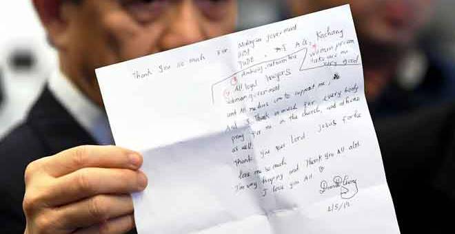 HANTAR PULANG: Hisyam menunjukkan surat yang ditulis anak guamnya Doan ketika sidang media berhubung pembebasan warga Vietnam yang dihantar pulang ke negara asalnya, di Lapangan Terbang Antarabangsa Kuala Lumpur, Sepang, semalam. — Gambar Bernama