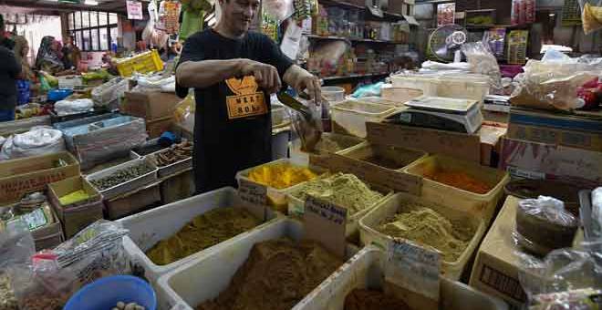 PERMINTAAN TINGGI MENJELANG PERAYAAN: Tun Hasan membungkus rempah ratus yang diminta pelanggan ketika tinjauan di Pasar Besar Kedai Payang di Kuala Terengganu baru-baru ini. — Gambar Bernama