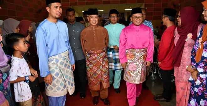 CERIA: Muhyiddin diiringi Menteri Besar Johor Datuk Sahruddin Jamal (kiri) dan Menteri Besar Selangor Amirudin Shari (kanan) ketika hadir pada Majlis Sambutan Hari Raya Aidilfitri Peringkat Parlimen Pagoh di Dewan Orang Ramai FELDA Sri Ledang dekat Muar, semalam. — Gambar Bernama