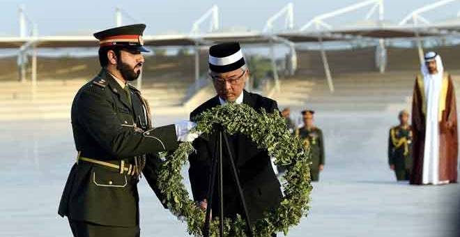 TANDA PENGHORMATAN: Al-Sultan Abdullah Riayatuddin (dua kiri) menyentuh kalungan bunga sebagai simbolik tanda penghormatan kepada wira yang gugur semasa lawatan ke Wahat Al-Karama (Oasis of Dignity)- peringatan bagi wira-wira UAE yang terkorban di Abu Dhabi, semalam. — Gambar Bernama