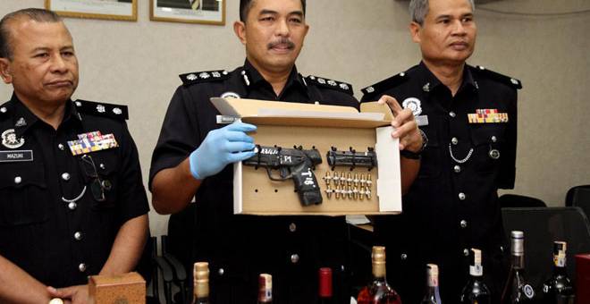 TUMPAS: ACP Mohd Ali (tengah) menunjukkan sepucuk pistol dan 14 butir peluru serta barangan rampasan susulan penahanan dua lelaki di Pasir Puteh, pada sidang media di Ibu Pejabat Polis Daerah Ipoh (IPD), Ipoh semalam. — Gambar Bernama