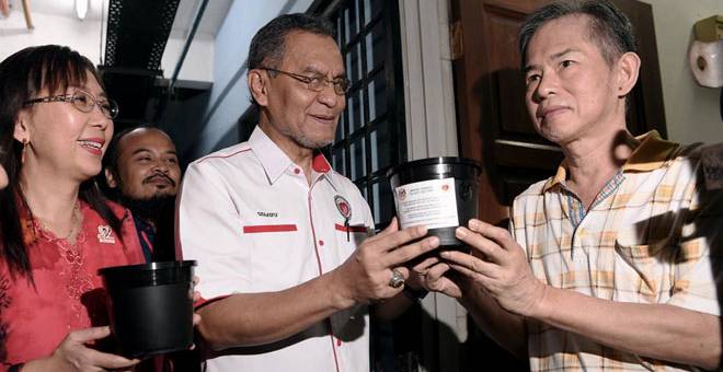 HAPUS AEDES: Dr Dzulkefly bersama Teresa Kok menyerahkan bekas pelepasan telur nyamuk aedes berWolbachia kepada penduduk sempena pelancaran kempen ‘KICK-OFF’ Pelepasan Telur Nyamuk Aedes Berwolbachia di Aparment Sri Rakyat Bukit Jalil semalam. — Gambar Bernama