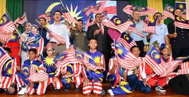 EXCO-BENDERA:  Pengerusi Jawatankuasa Perumahan, Komunikasi dan Multimedia Negeri Johor Dzulkefly Ahmad (empat kanan) bersama para pelajar Sekolah Menengah Kebangsaan Kelapa Sawit Kulai menyanyikan lagu Jalur Gemilang pada Perasmian Program MyMerdeka Sayangi Malaysiaku; Malaysia Bersih 2019 di Mydin Mutiara Rini Skudai semalam. — Gambar Benama