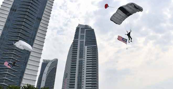 PERTUNJUKAN: Penerjun dari Malaysia BASEjumper tidak ketinggalan menyemarakkan semangat patriotik dengan mengadakan pertunjukan ‘base jump’ sambil mengibarkan Jalur Gemilang dari bangunan Kementerian Pembangunan Wanita, Keluarga dan Masyarakat, Presint 4 semalam. — Gambar Benama