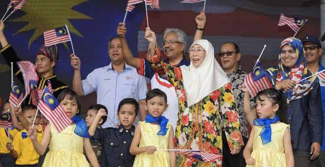 PERPADUAN:  Wan Azizah (belakang dua kanan) bersama P. Waytha Moorthy (belakang tiga kanan) mengibarkan Jalur Gemilang sambil menyanyikan lagu patriotik bersama kanak-kanak Tabika Perpaduan pada Majlis Festival Merdeka #PERPADUANDIHATI di Dataran Padang Majlis Perbandaran Ampang Jaya semalam. — Gambar Benama