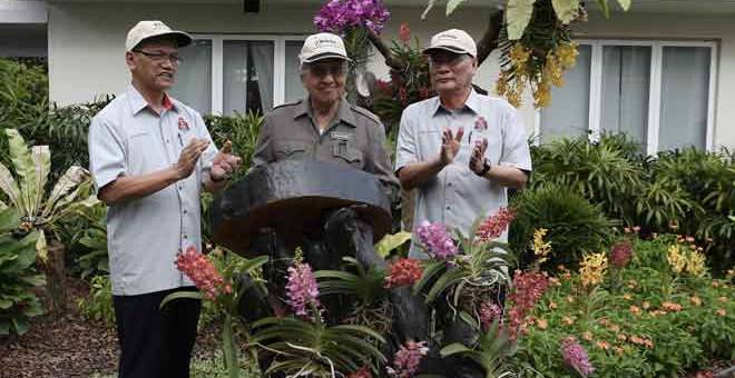 PERASMIAN: Perdana Menteri Tun Dr Mahathir Mohamad menandatangani plak perasmian Pusat Pelawat, Herbarium dan Taman Etnobotani di Taman Botani Perdana semalam.  — Gambar Bernama