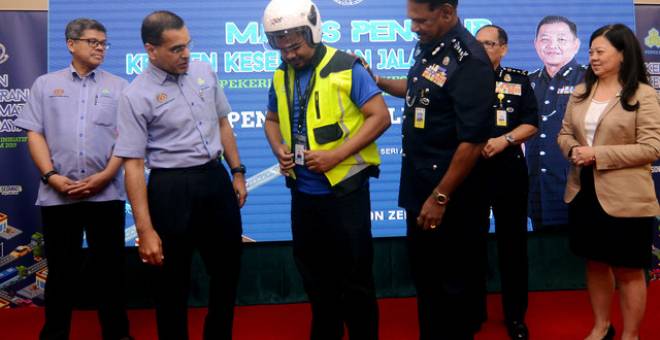 Ketua Polis Pulau Pinang Datuk T. Narenasagaran (tiga, kanan) memakaikan pakaian keselamatan kepada pekerja Flex Penang Mohamad Danial Abdul Razak pada Majlis Penutup Program Kempen Kesedaran Keselamatan Jalan Raya Inisiatif Perkeso dan Polis Diraja Malaysia (PDRM) dengan kerjasama Flex Penang sempena Hari Polis Ke-212 hari ini. Turut hadir Ketua Pegawai Eksekutif Pertubuhan Keselamatan Sosial (Perkeso) Datuk Seri Dr Mohammed Azman Aziz Mohammed (dua, kiri) dan Pengurus Besar Flex Penang Ooi Siew Mei (kanan