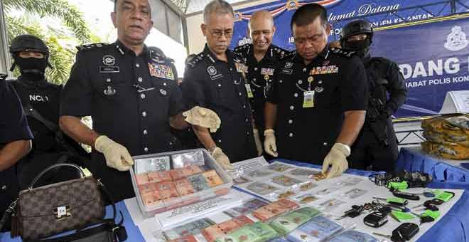 PERANGI DADAH: Mohd Khalil  (dua kiri) bersama Hasanuddin (empat kanan) menunjukkan sejumlah wang tunai yang dirampas dalam Op Toucan dan Op Damn Tokan pada sidang media di Ibu Pejabat Polis Kontinjen Kelantan semalam. — Gambar Bernama 