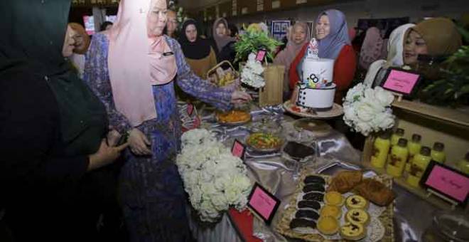 MESRA: Rina (dua kiri) ketika mengadakan lawatan ke gerai pameran produk dari KEMAS pada Program Wanita Inspirasiku (WINS) Peringkat Negeri Sembilan di Politeknik Nilai, semalam.  — Gambar Benama