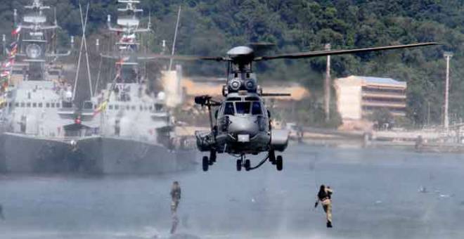 HANDAL: Anggota Pasukan Khas Laut (PASKAL) bergayut di pesawat helikopter Super Lynx dalam demonstrasi menyelamatkan tebusan bersempena Hari Angkatan Tentera Malaysia (ATM) Ke-86 di Pangkalan Tentera Laut DiRaja Malaysia (TLDM) Lumut semalam. — Gambar Benama