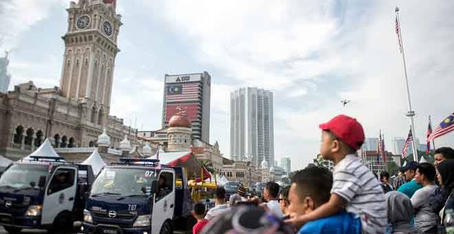 MENYAKSIKAN: Orang ramai tidak melepaskan peluang untuk menyaksikan perarakan kontinjen dan kenderaan penguatkuasa Dewan Bandaraya Kuala Lumpur (DBKL) sempena Sambutan Hari Penguatkuasa ke-50 Jabatan Penguatkuasaan DBKL di Dataran Merdeka semalam. — Gambar Bernama