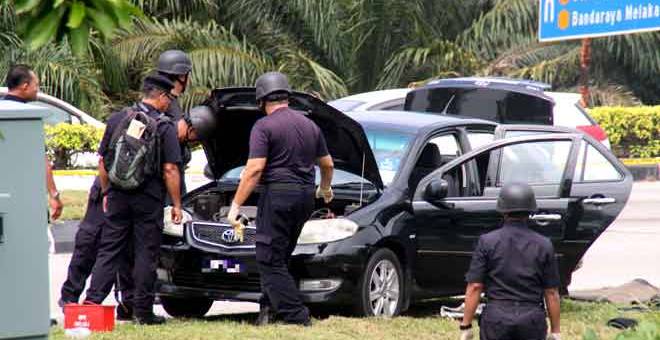 DITAHAN: Unit Pemusnah Bom dari IPK Melaka memeriksa kenderaan yang ditahan di persimpangan lampu isyarat Lebuh Alor Gajah-Melaka-Jasin Serkam Merlimau Jasin, di Jasin, kelmarin. — Gambar Bernama