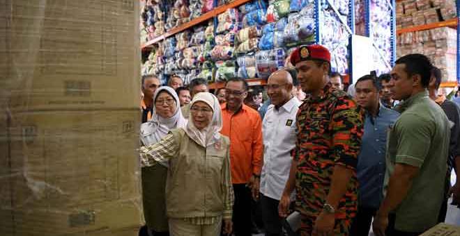 MENCUKUPI: Wan Azizah (dua kiri) melihat barang keperluan mangsa banjir ketika melawat Depot Simpanan Kuantan Jabatan Kebajikan Masyarakat (JKM) bagi menghadapi Monsun Timur Laut semalam. — Gambar Bernama