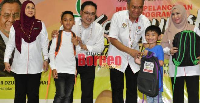 Dr Dzulkefly ditemani Chong menyampaikan beg sekolah kepada murid sempena program Kampungku Sihat Peringkat Parlimen Stampin di Kampung Tematu.