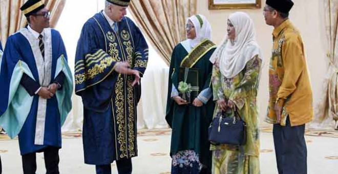 MESRA: Sultan Nazrin (dua kiri) yang juga Canselor Universiti Sultan Azlan Shah berkenan beramah mesra bersama penerima Anugerah Tuanku Canselor yang merupakan Graduan Ijazah Sarjana Muda Syariah Gunaan, Amirah Mursyidah Zainal abidin (tengah) pada Istiadat Konvokesyen Ke-12 Universiti Sultan Azlan Shah di Dewan Jubli Perak semalam. — Gambar Bernama