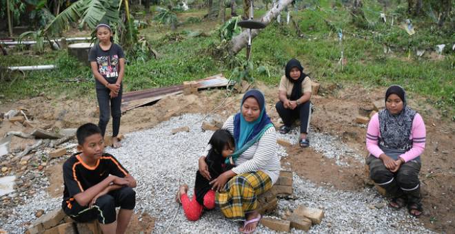 Mangsa banjir Suriati Mohd Yusof, 35, (tiga, kanan) bersama tiga anaknya Adam Danish Hardi Mazda, 14, (kiri), Nur Syalina Hartini, 12, (dua, kiri) dan Aliya Danisha, 7, serta dua adiknya Siti Nur Fazlida Mohd Asri, 22, (kanan) dan Nur Azila Mohd Yusof, 19, duduk di tapak rumah yang didiami sejak setahun lalu dihanyutkan banjir yang melanda Kampung La, Jerteh enam hari lalu. - Gambar Bernama 