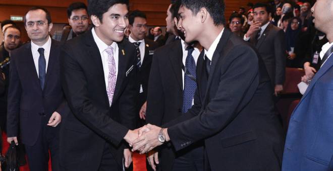 Syed Saddiq bertanya khabar dengan salah seorang delagasi pada Sidang Kemuncak Belia Kuala Lumpur hari ini.  - Gambar Bernama 