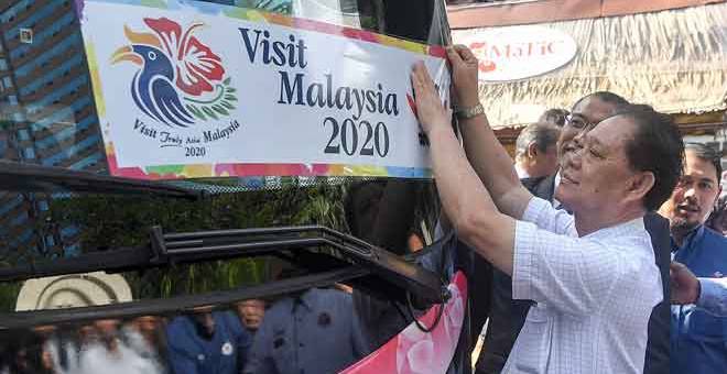 VM2020: Mohamaddin melekatkan pelekat kenderaan MATTA yang dilancarkan sempena Tahun Melawat Malaysia 2020 (VM2020) pada sebuah bas di Pusat Pelancongan Malaysia (MaTiC) semalam. — Gambar Bernama