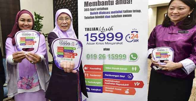 KEMPEN: Wan Azizah (dua kiri) menunjukkan nombor talian tetap, telefon bimbit dan telefon awam Talian Kasih pada majlis Perhimpunan Bulanan Kementerian Pembangunan Wanita, Keluarga dan Masyarakat (KPWKM) di ibu negara semalam. Turut hadir ialah Hannah Yeoh dan Junaidah (kiri). — Gambar Bernama