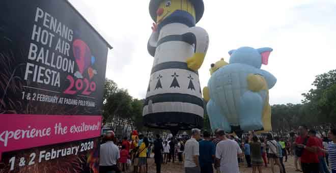 MERIAH: Orang ramai teruja melihat dua buah belon udara panas bersaiz besar yang dipamerkan di Padang Pasar Malam Farlim pada ‘Pop Up Hot Air Balloon Fiesta’ semalam. Pesta Belon Udara Panas Pulau Pinang akan berlangsung pada Sabtu dan Ahad ini di Padang Polo, George Town. — Gambar Bernama