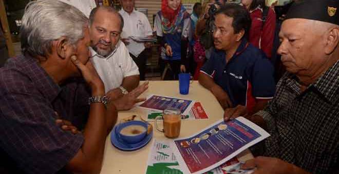 PENERANGAN: Menteri Komunikasi dan Multimedia Gobind Singh Deo memberi penerangan serta mengedarkan risalah mengenai pencegahan jangkitan 2019 Novel Koronavirus (2019-nCoV) pada Program ‘Info On Wheels’ di Astaka Bukit Gedung, George Town semalam. — Gambar Bernama