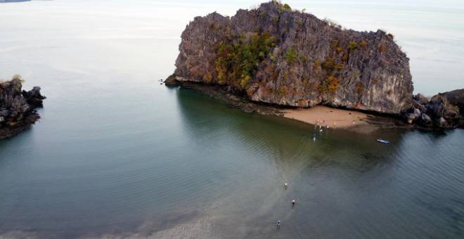 Para pengunjung di Pantai Tanjung Rhu, pagi ini teruja apabila berpeluang berjalan hampir 600 meter bermula dari pantai tersebut hingga ke tiga pulau kecil berhampiran berikutan fenomena laut seakan terbelah sehingga menampakkan beting pasir.  - Gambar Bernama