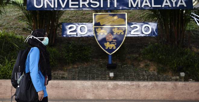 Penuntut Universiti Malaya, Izzah Azami melintasi logo Universiti Malaya ketika tinjauan hari ini. - Gambar Bernama 