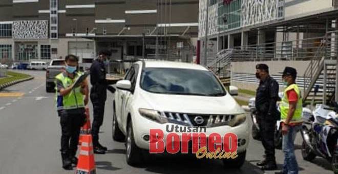 Anggota polis melakukan sekatan jalan raya pada hari kedua penguatkuasaan Perintah Kawalan Pergerakan di bandar raya Kuching, hari ini.