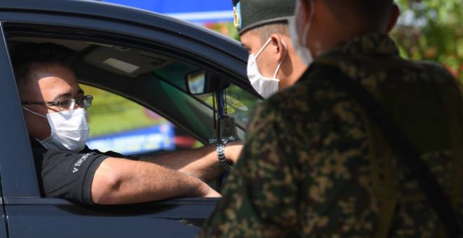 Anggota tentera di 4 Renjer Rejimen Sempadan Bukit Cowder membantu polis ketika mengadakan sekatan jalan raya bagi memastikan rakyat mematuhi Perintah Kawalan Pergerakan (PKP) ketika tinjauan fotoBernama di sempadan antara Kedah dan Perlis hari ini. - Gambar Bernama