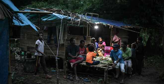 BERKUMPUL: Sebahagian masyarakat Orang Asli Suku Kensui  berbuka puasa ketika tinjauan di Kampung Lubuk Legong, Baling.  — Gambar Bernama