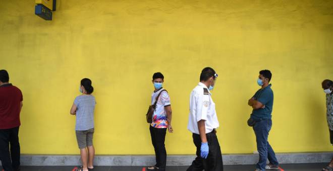 Orang ramai beratur sambil mengamalkan penjarakkan sosial satu meter dan memakai penutup hidung dan mulut ketika berurusan dengan syarikat telekomunikasi ketika tinjauan di Kuantan, baru-baru ini - Gambar Bernama