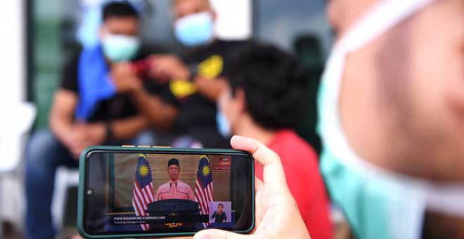  Petugas barisan hadapan terdiri daripada petugas Kementerian Kesihatan (KKM) menonton perutusan khas Perdana Menteri Tan Sri Muhyiddin Yassin selepas selesai tugas pemeriksaan saringan ketika tinjauan di sekitar Petaling Jaya, hari ini. - Gambar Bernama 