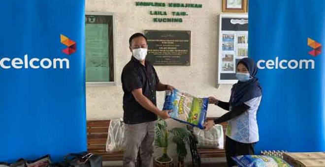 KONGSI KASIH SAYANG: Wakil dari Jabatan Perniagaan Perusahaan Celcom menyerahkan sumbangan kepada salah seorang penghuni Kompleks Kebajikan Laila Taib di Sarawak.