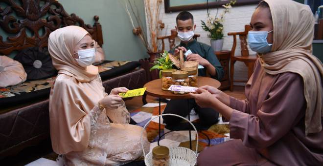 Nur Arysha Mohd Saad (kiri) bersama saudaranya Ili Atiqah Shahruddin (kanan) dan Adam Ikhwan Mohd Nur Azam (tengah) menyambut Hari Raya Aidilfitri di kediamannya di Kampung Baru. - Gambar Bernama 