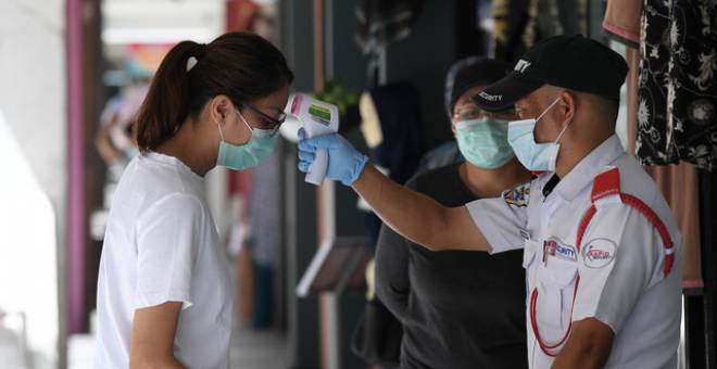  Pengawal keselamatan mengambil bacaan suhu badan setiap pelanggan sebelum dibenarkan memasuki pasaraya bagi mengekang penularan COVID-19 ketika tinjauan di ibu negara baru-baru ini. - Gambar Bernama