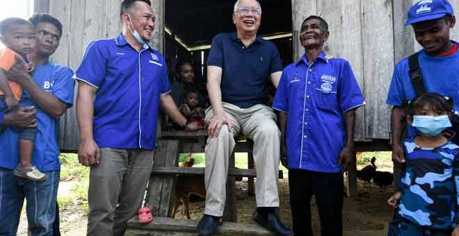 MESRA: Ahli Parlimen Pekan, Datuk Seri Najib Tun Razak (tengah) dan calon Barisan Nasional, Mohd Sharim Md Zain (dua kiri) dan  beramah mesra bersama Tok Batin Manda Mat ketika bertemu masyarakat Orang Asli suku Jakun di Kampung Orang Asli Bendaling, pekan semalam. — Gambar Bernama