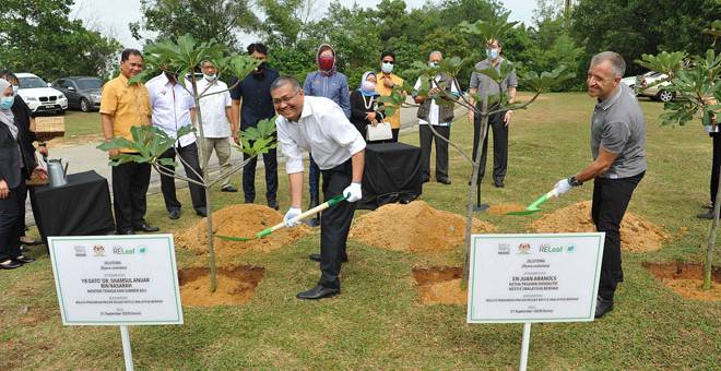 JANJI GLOBAL: Shamsul Anuar (kiri) dan Juan menanam pokok di Taman Rimba Alam, Putrajaya.