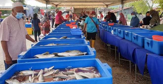 BERPATUTAN: Orang ramai mengunjungi gerai menjual bekalan makanan segar dan berkualiti dengan harga berpatutan kepada masyarakat pada Program Jualan Masyarakat, semalam. — Gambar Bernama