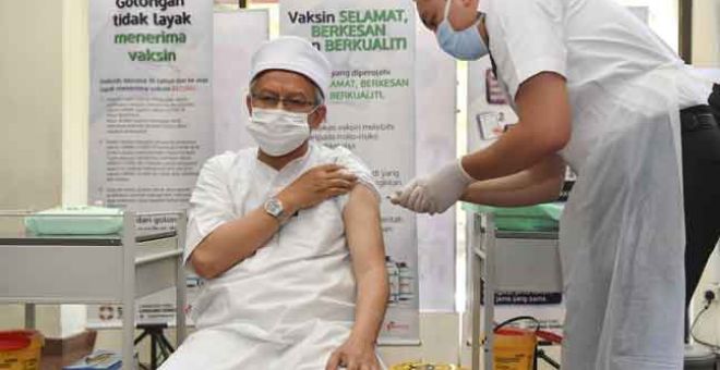 DISUNTIK: Zulkifli ketika menerima suntikan vaksin COVID-19 jenis Pfizer BioNTech  oleh Vaksinator, Muhammad Bakhrul Ulum Mohd Rashid di Pejabat Kesihatan Putrajaya, Presint 11 semalam. — Gambar Bernama