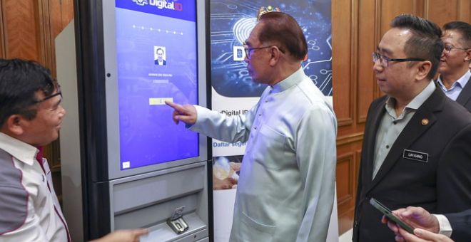 Anwar (tengah) mendaftarkan diri dengan Identiti Digital Nasional atau Digital ID di Bangunan Perdana Putra hari ini.  Turut sama Menteri Sains, Teknologi dan Inovasi, Chang Lih Kang (kanan). - Gambar BERNAMA