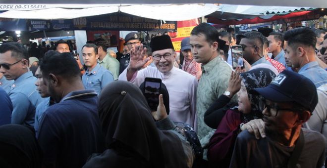 Anwar menyantuni orang ramai semasa meluangkan masa kira-kira sejam mengunjungi Bazar Ramadan Mahkota Square hari ini.-Gambar BERNAMA