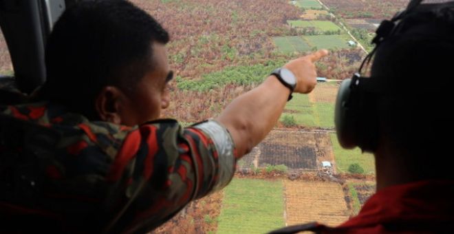 Ismail menunjukkan kawasan hutan yang terbakar di Gebeng semasa melakukan tinjauan operasi pemadaman dengan menaiki helikopter MI17. - Gambar BERNAMA